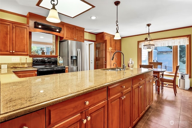 kitchen with light stone countertops, sink, decorative light fixtures, stainless steel refrigerator with ice dispenser, and black range with electric cooktop