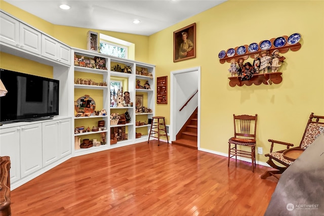 living area featuring lofted ceiling and light hardwood / wood-style floors