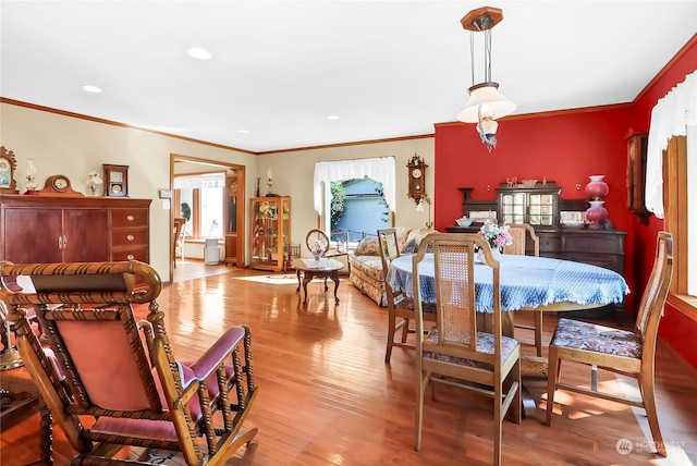 dining area with light hardwood / wood-style flooring and ornamental molding