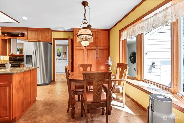 tiled dining area featuring crown molding