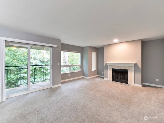 unfurnished living room with light carpet and a fireplace