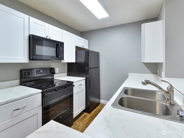 kitchen featuring dark hardwood / wood-style flooring, sink, white cabinetry, and black appliances