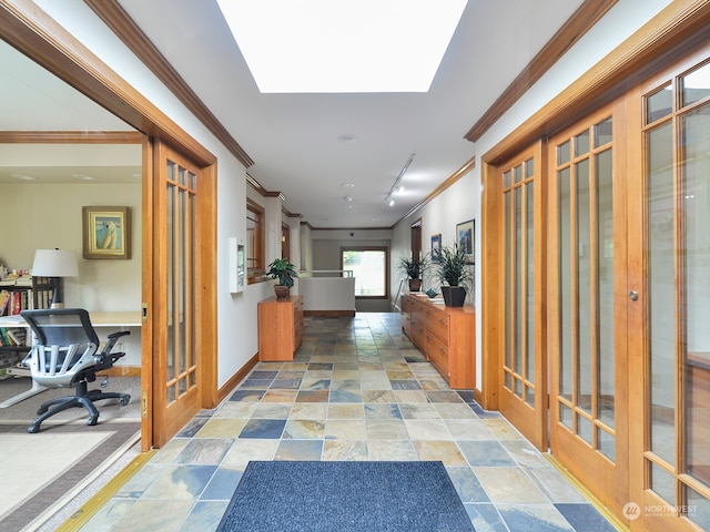 hallway featuring a skylight and crown molding