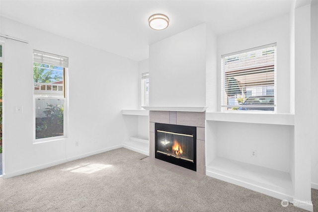 unfurnished living room with light colored carpet and a fireplace