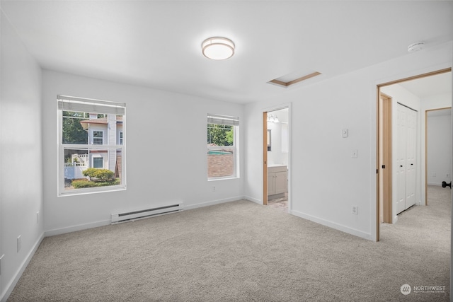 unfurnished bedroom with light colored carpet, baseboard heating, connected bathroom, and a closet