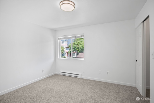 unfurnished bedroom with carpet, a closet, and baseboard heating