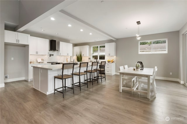 kitchen with light wood-type flooring, white cabinetry, and a kitchen island