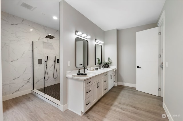 bathroom featuring a tile shower, vanity, and hardwood / wood-style floors