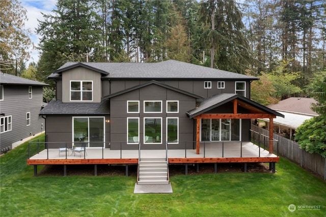 back of property with a yard and a wooden deck