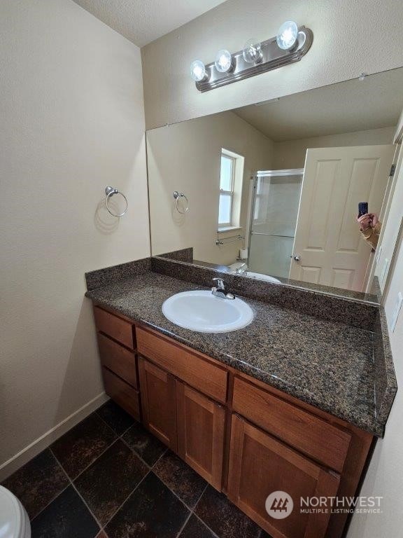 bathroom with walk in shower, toilet, a textured ceiling, and vanity