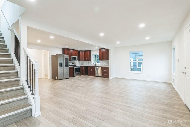 unfurnished living room featuring light hardwood / wood-style floors and sink