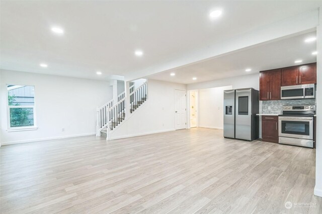 kitchen with appliances with stainless steel finishes, tasteful backsplash, and light hardwood / wood-style flooring