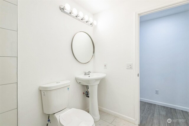 bathroom with toilet and hardwood / wood-style floors