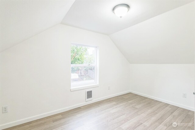 bonus room featuring light wood-type flooring and vaulted ceiling