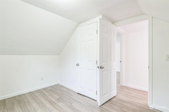 additional living space with light wood-type flooring and lofted ceiling