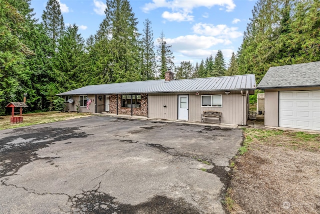 ranch-style house with a garage and an outbuilding