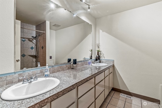 bathroom featuring vanity, tiled shower, and tile patterned floors