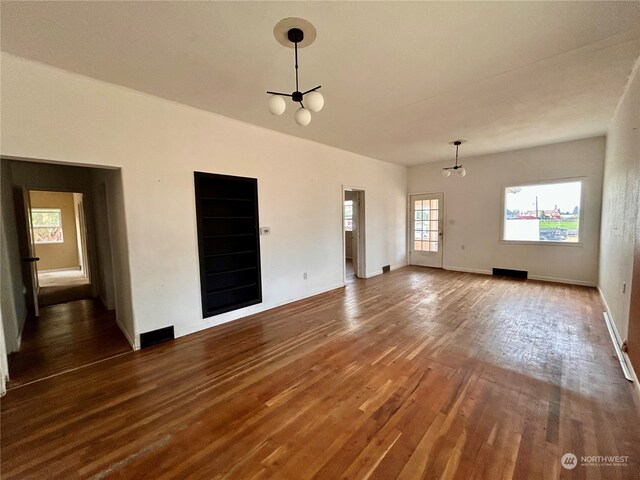 unfurnished room with hardwood / wood-style flooring and a notable chandelier