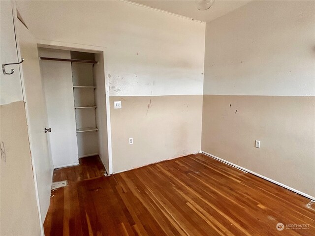 unfurnished bedroom with dark wood-type flooring and a closet