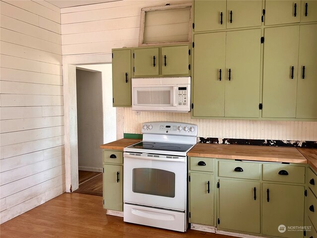 kitchen with green cabinets, wooden walls, light hardwood / wood-style flooring, wood counters, and white appliances