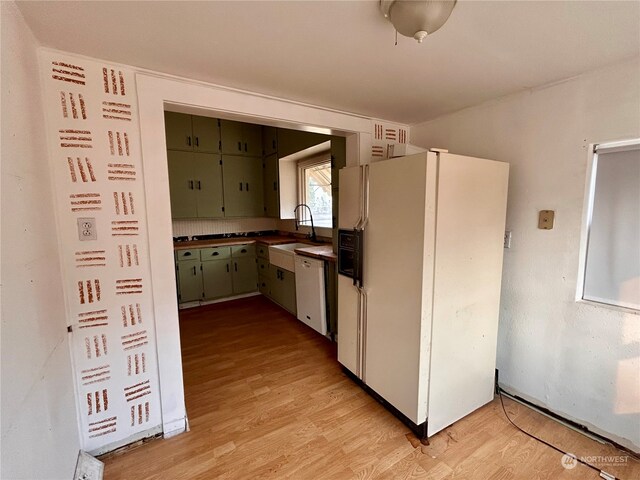 kitchen with white appliances, light hardwood / wood-style flooring, and sink