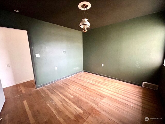 unfurnished room with hardwood / wood-style flooring