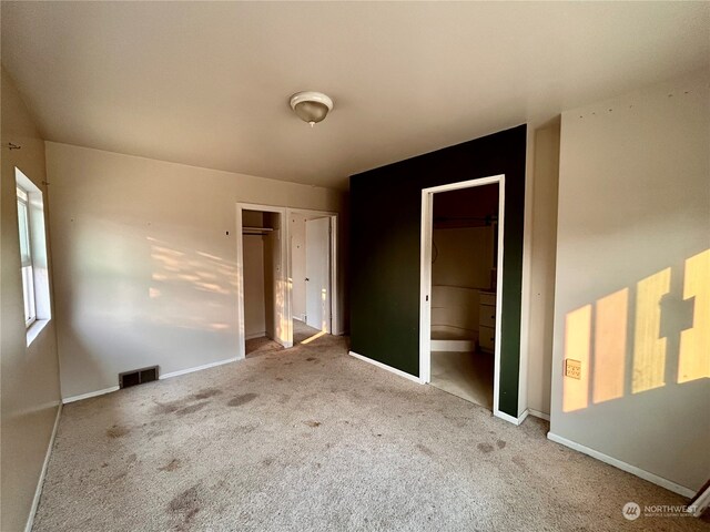 unfurnished bedroom featuring carpet and ensuite bath