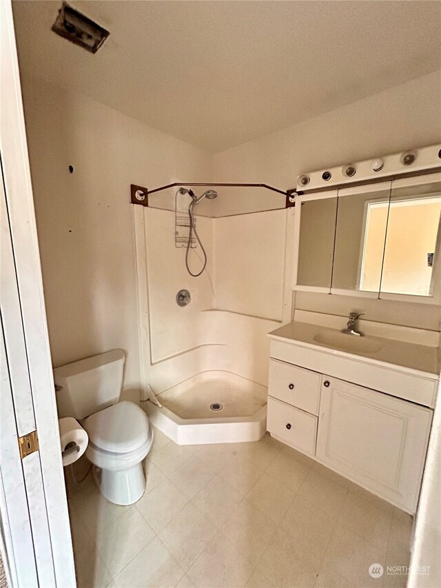 bathroom with walk in shower, toilet, and vanity