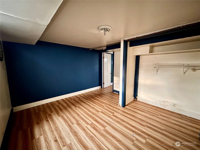 unfurnished bedroom with a closet and wood-type flooring