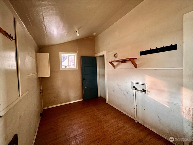 interior space with dark wood-type flooring and vaulted ceiling