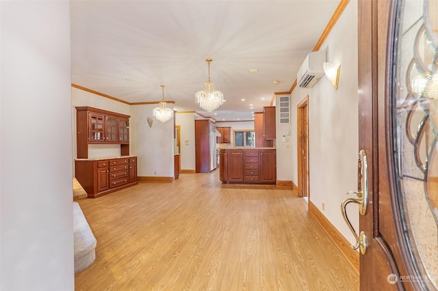 kitchen with a wall mounted air conditioner, a notable chandelier, light wood-type flooring, and hanging light fixtures