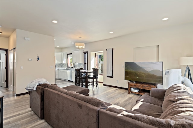 living room featuring sink and light hardwood / wood-style floors