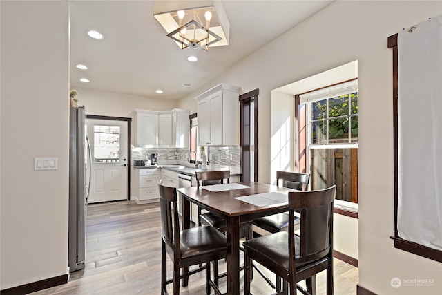 dining area featuring a wealth of natural light, a chandelier, light hardwood / wood-style floors, and sink