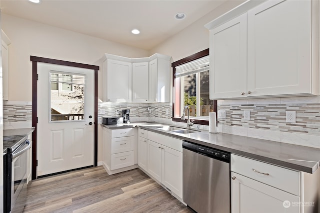 kitchen featuring light hardwood / wood-style floors, white cabinetry, tasteful backsplash, stainless steel appliances, and sink