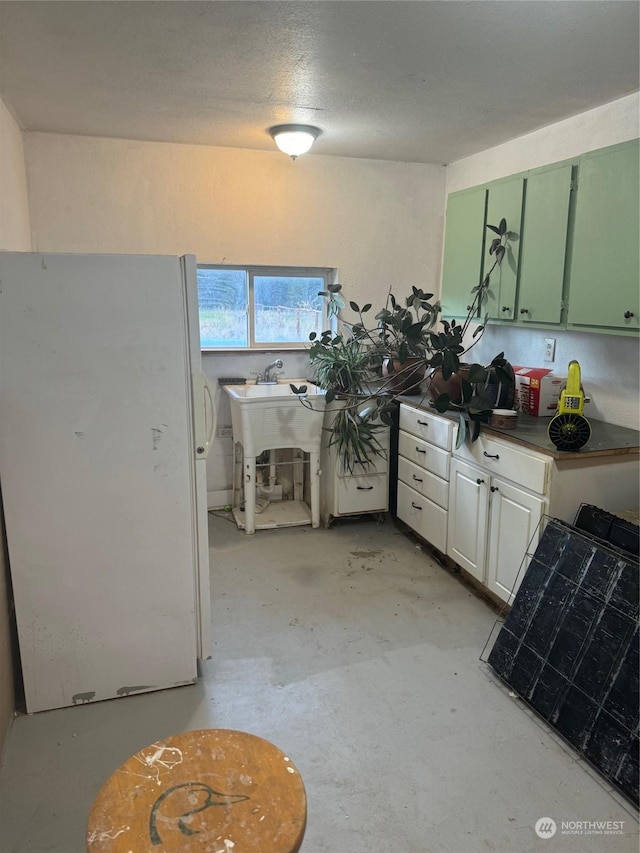 18 Chukar Ln, Riverside, WA 98849 - kitchen featuring green cabinets, freestanding refrigerator, and concrete flooring