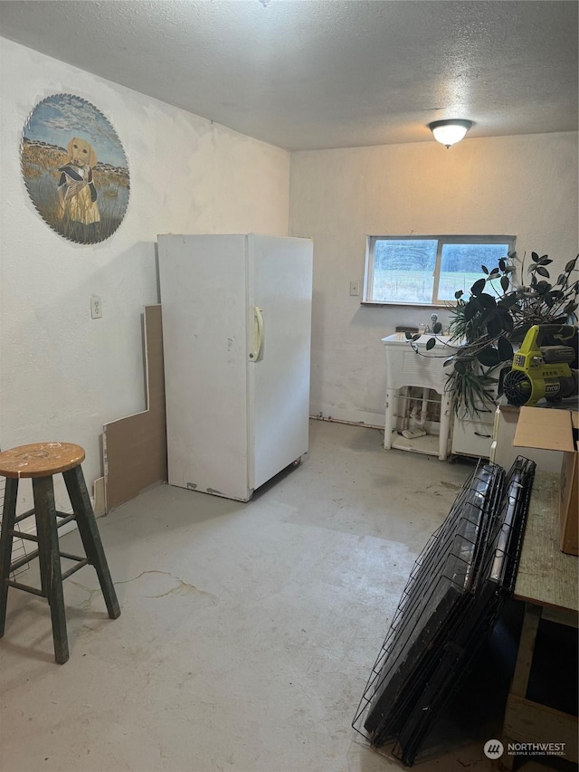 18 Chukar Ln, Riverside, WA 98849 - kitchen with freestanding refrigerator, unfinished concrete floors, and a textured ceiling