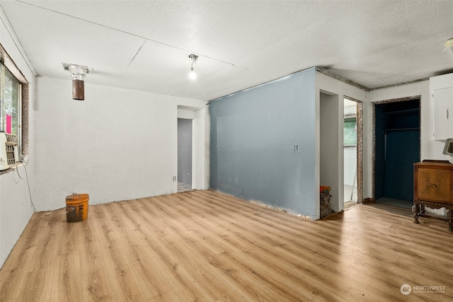 spare room featuring a textured ceiling and light hardwood / wood-style flooring