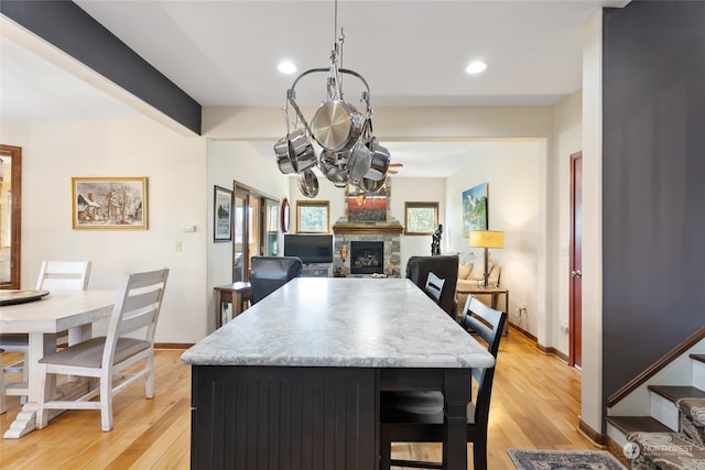 interior space with plenty of natural light, light hardwood / wood-style floors, and a stone fireplace