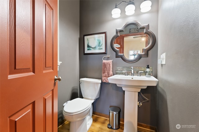 bathroom with hardwood / wood-style floors and toilet