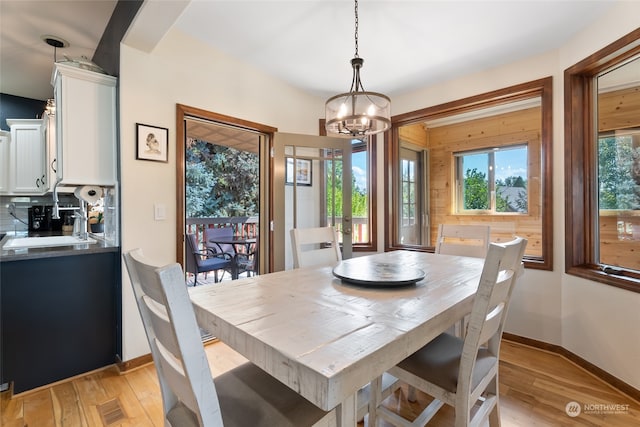 dining area featuring light wood-type flooring and a chandelier