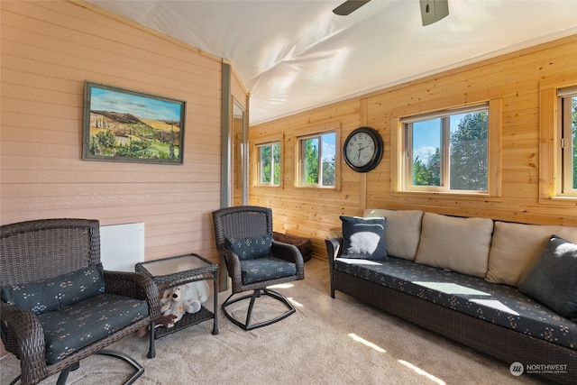 living room with light carpet, a healthy amount of sunlight, ceiling fan, and wooden walls