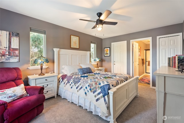 carpeted bedroom featuring a closet, ceiling fan, and ensuite bathroom