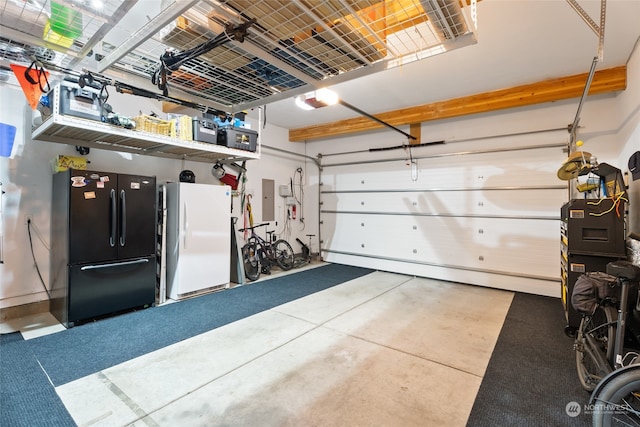 garage featuring black fridge, white refrigerator, and electric panel