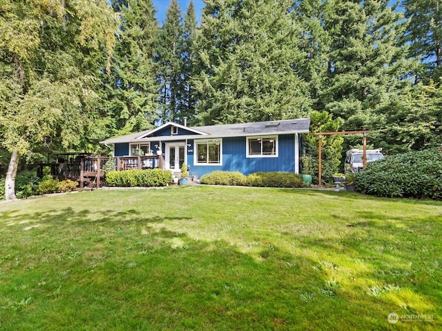 view of front of house featuring a wooden deck and a front lawn