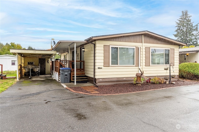 manufactured / mobile home featuring a storage shed and a carport