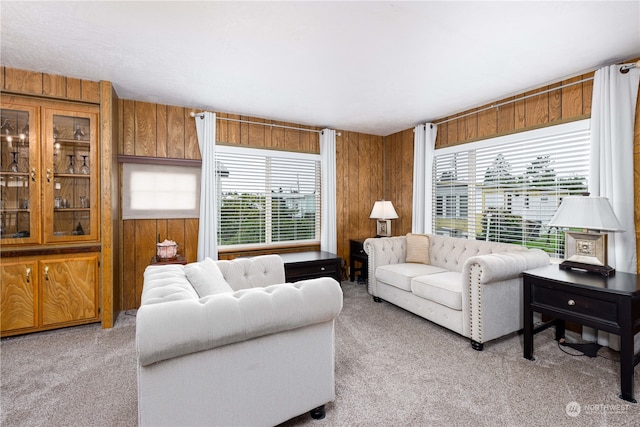 carpeted living room featuring wood walls