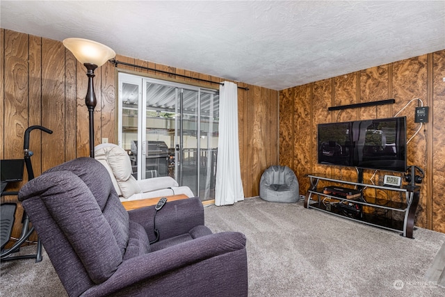 carpeted living room featuring a textured ceiling and wooden walls