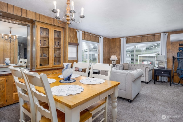 dining room featuring a wall unit AC, a wealth of natural light, and a chandelier