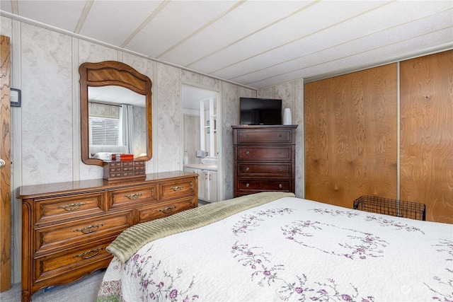 carpeted bedroom featuring ensuite bath