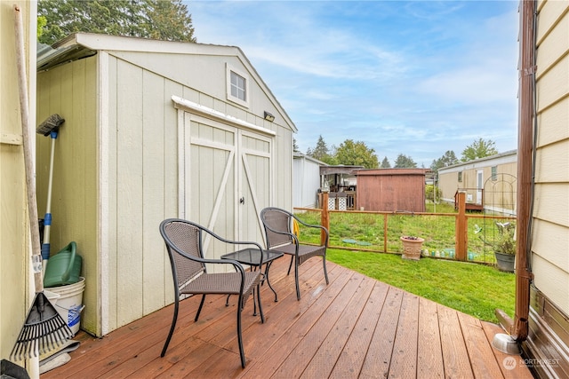 wooden terrace featuring a storage shed and a lawn